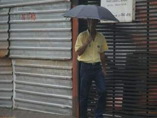 Homem com guarda-chuva em Campo Grande. (Foto: Marcos Ermínio)