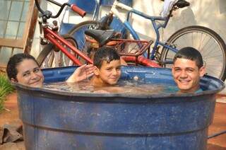 Lucineide e os dois filhos aderiram ao banho em caixa d&#039;água (Foto: Marcelo Calazans)