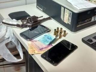 Arma, celulares e dinheiro foram apreendidos. (Foto: Simão Nogueira)