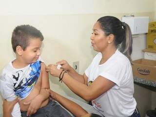 Criança recebe vacina em unidade de saúde em Campo Grande. Quatro centros regionais funcionam neste domingo (20). (Foto: Paulo Francis)