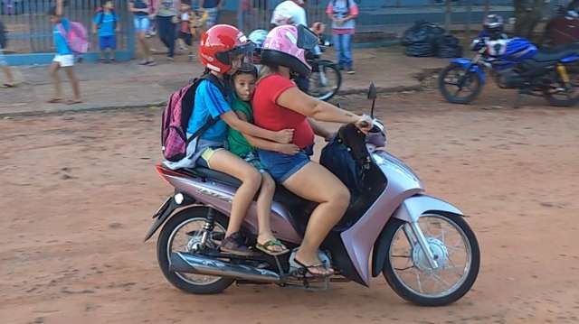 Na sa&iacute;da da escola, pais levam filhos de moto sem capacete e no carro sem cinto
