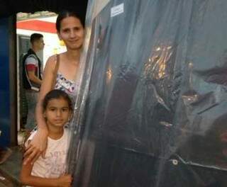 Aline, ao lado da filha, e segurando o colchão, que comprou pela metade do preço (Foto: Osvaldo Júnior)