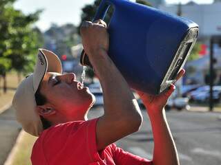 Rapaz toma água na Afonso Pena, para suportar tempo seco.