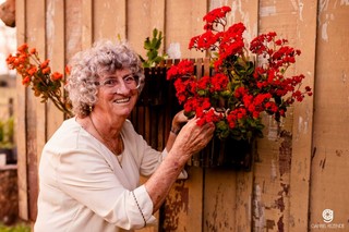 Aos 78 anos, Elzira posa ao lado das flores que enfeitam o jardim (Foto: Gabriel Rezende)