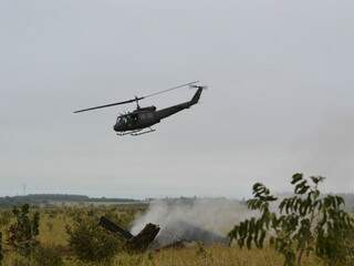 Helicóptero sobrevoa área do acidente, na região do Indubrasil. No chão, destroços do avião em meio a fumaça. (Foto: Simão Nogueira)  