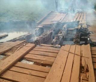 A ponte de madeira em estrada de distrito de Dourados foi queimada e não há previsão de quando uma nova será construída (Foto: Divulgação/Assecom)