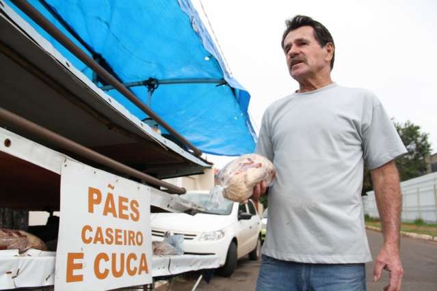 Em carrinho at&eacute; com retrovisor, homem anda 30 km por dia vendendo cucas e p&atilde;es