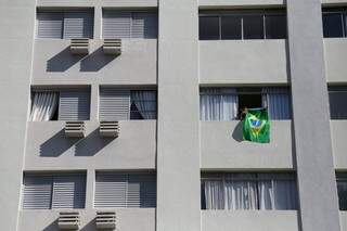 Nas janelas, moradores se manifestam usando a bandeira do Brasil (Foto: Marcos Ermínio)