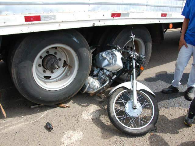  Motociclista tenta podar caminh&atilde;o e tem moto presa no pneu do ve&iacute;culo