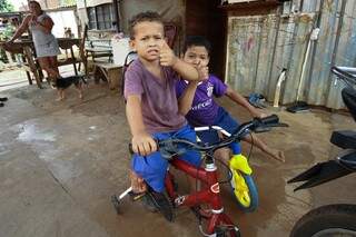 Crianças durante as férias brincam na varanda de casa. Famílias aguardam por vagas em creche. (Foto: Saul Schramm)