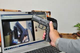 Delegado mostra a arma de verdade e, no computador, o simulacro vendido por Marcos Paulo Caiado. (Foto: João Garrigó)