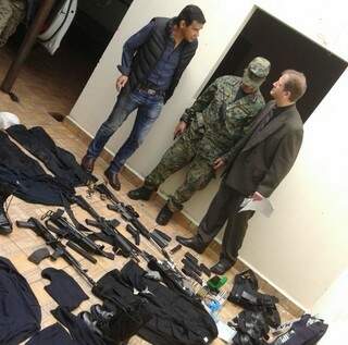 Policiais paraguaios observam armamento e roupas que podem ter sido usados por pistoleiros (Foto: Leo Veras/Ponta Porã Digital)