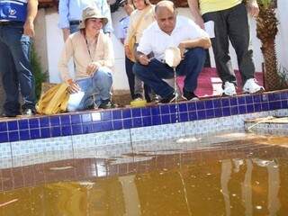 Ministro do Esporte, George Hilton, recolhe larvas do mosquito Aedes aegypti em piscina abandonada no Aero Rancho (Foto: Fernando Antunes)