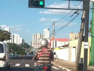 Motociclista levando criança presa ao peito (Foto: Direto das ruas)