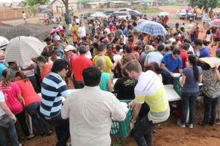 Mesmo debaixo de chuva, moradores e voluntários permaneceram até o final da entrega. (Foto: Marcos Ermínio)