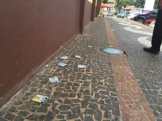 Santinhos espalhados na calçada do Mercadão (Foto: Direto das Ruas)