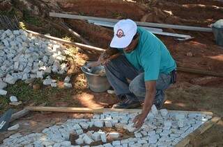 Pedras portuguesas são recuperadas e recolocadas nas ruas. (Foto:Divulgação)