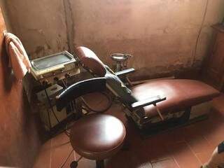 Cadeira rasgada e enferrujada ao lado de equipamentos sucateados no consultório clandestino (Foto: CRO-MS) 