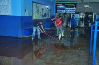 Funcionários retiram água da chuva em escola (Foto: João Carrigó)