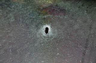 Marca de bala em veículo de jovem que passava por local de confronto. (Foto: Fernando Antunes)