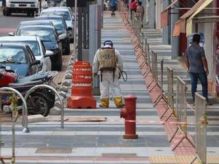 Operário aplica resina sobre piso fulget instalado ao longo de 1,4 km da Rua 14 de Julho (Foto: Marcos Maluf)