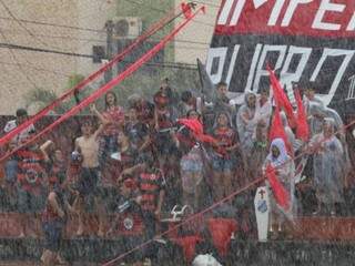Torcida embaixo de chuva na arquibancada do estádio Ninho da Águia (Foto: Franz Mendes)