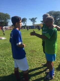 Gonçalves e Copeu conversam com garoto na unidade da escolinha pública de futebol que já começaram a comandar no Jardim Monumenta em Campo Grande (Foto: Bruno Nóbrega)