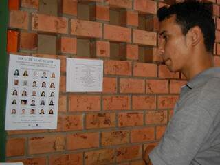 Jovem confere número de candidato e questiona pouca divulgação sobre os locais de votação. (Foto: Simão Nogueira)