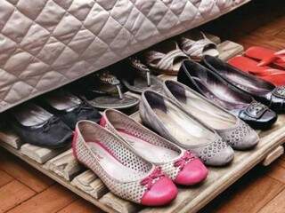 Sapatos sob a cama, mas bem organizados.