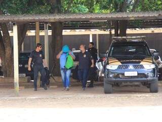 Suspeito esconde o rosto ao chegar à sede da polícia (Foto: Marina Pacheco) 