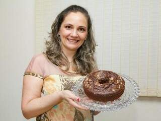 Adriana Morbi segurando o bolo de cacau com castanhas do Pará (Foto: Kisie Ainoã)