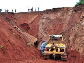 Máquinas começaram a trabalhar esta manhã em cratera aberta pelas chuvas de verão no Nova Lima.(Foto: João Garrigó) 