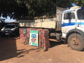 Pilhas de tabletes de maconha e as armas ao lado do caminhão apreendido hoje em Eldorado (Foto: Divulgação)