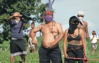Usando máscara e com um revólver na mão direita, índio lidera grupo que ocupa fazenda em Caarapó (Foto: Baltazar Fabiano/Alô Caarapó)