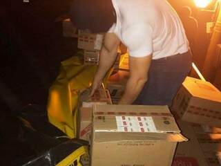 Policial verifica caixas de cigarro contrabandeado em carreta apreendida ontem (Foto: Divulgação)