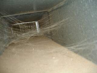Teias de aranha e poeira se acumulam nos dutos.