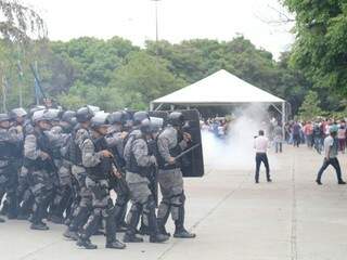 Batalhão de Choque agindo para conter o tumulto; ao fundo, a fumaça de uma bomba de feito moral (Foto: Marcos Ermínio)