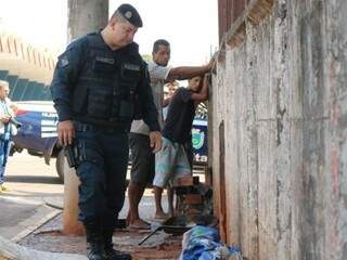 Policial olha situação onde &quot;vivem&quot; dependentes enquanto os revistados olham o policial (Foto: Marcos Maluf)