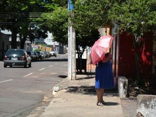 Mulher de sombrinha; objeto poderá ser usado nesta semana para proteção contra o sol e a chuva (Foto: Fernando Antunes/Arquivo)