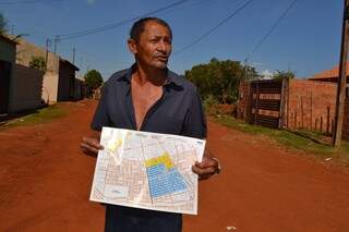 José guarda mapa de asfalto do bairro distribuído há um ano durante inauguração de parte da obra (Foto: Pedro Peralta)