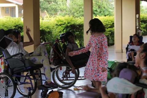 Menina inventa brincadeiras para fazer feliz quem tem paralisia cerebral