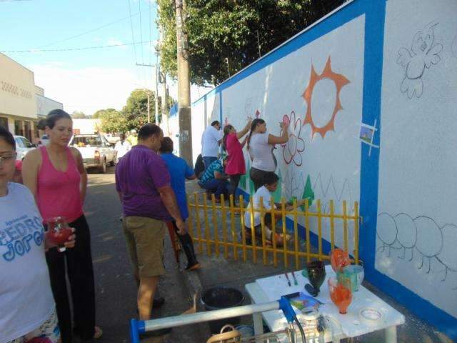 No lugar de festa e presente, pais comemoram o dia deles pintando o muro