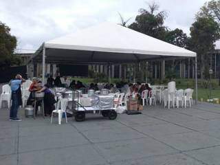 Trabalhadores servindo almoço em tenda em frente a Assembleia Legislativa, em Campo Grande (Foto: Liniker Fabrício)