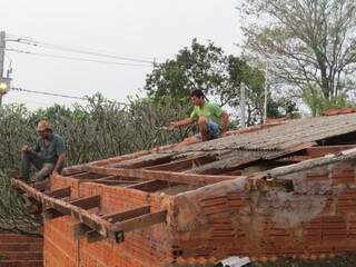 Logo após a chuva, moradores começaram a trocar telhas (Foto: Rodrigo Bossolani/Dourados News)