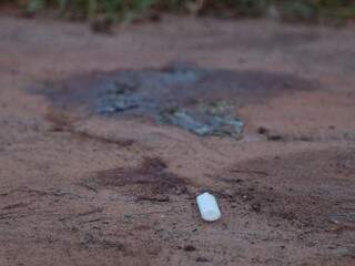 Isqueiro e poça de sangue onde o rapaz foi encontrado na Vila Nasser (Foto: Fernando Antunes) 