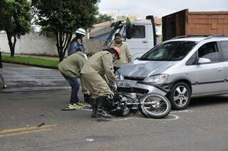 Bombeiros retiram moto debaixo de veículo após colisão (Foto: Marcelo Calazans)