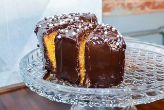 Bolos são simples e feitos na casa. Na foto, um de cenoura com cobertura de chocolate