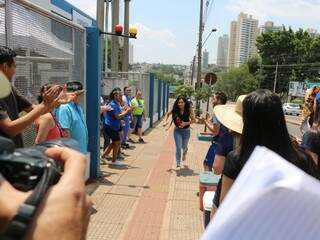 Candidata corre para chegar antes do fechamento do portão na Uniderp, um dos locais de provas em Campo Grande (Foto: Marcos Maluf)