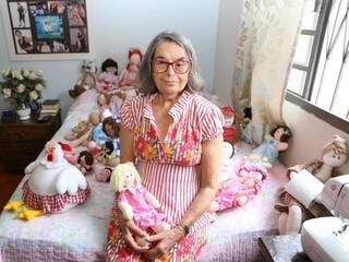 Ester Fernandes da Silva no quarto segurando uma das bonecas que fez. (Foto: Paulo Francis)