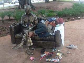 Morador de rua dormindo ao lado da estátua (Foto: Direto das Ruas)
